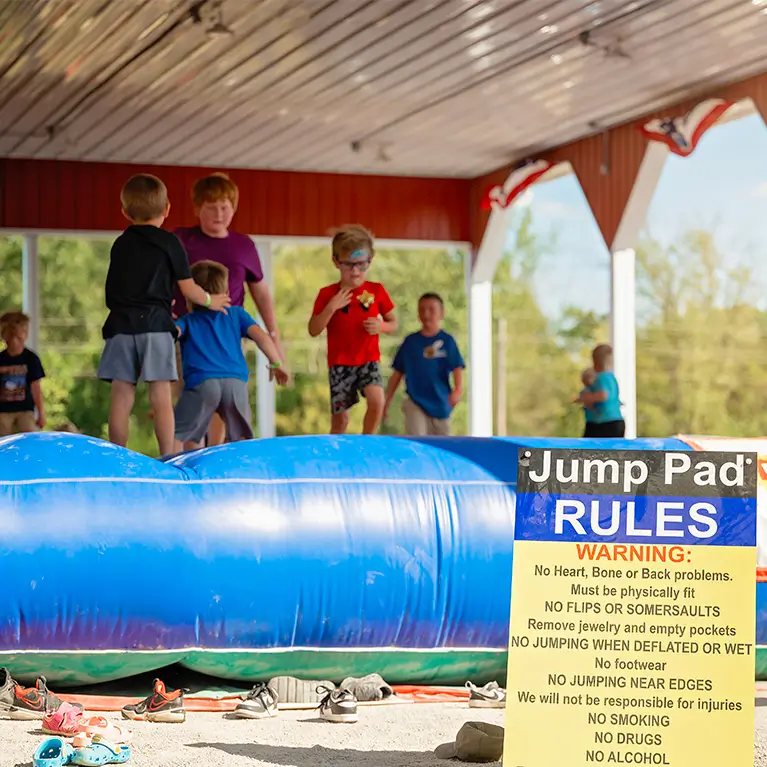 Kids jumping on a giant inflatable jumping pillow attraction.