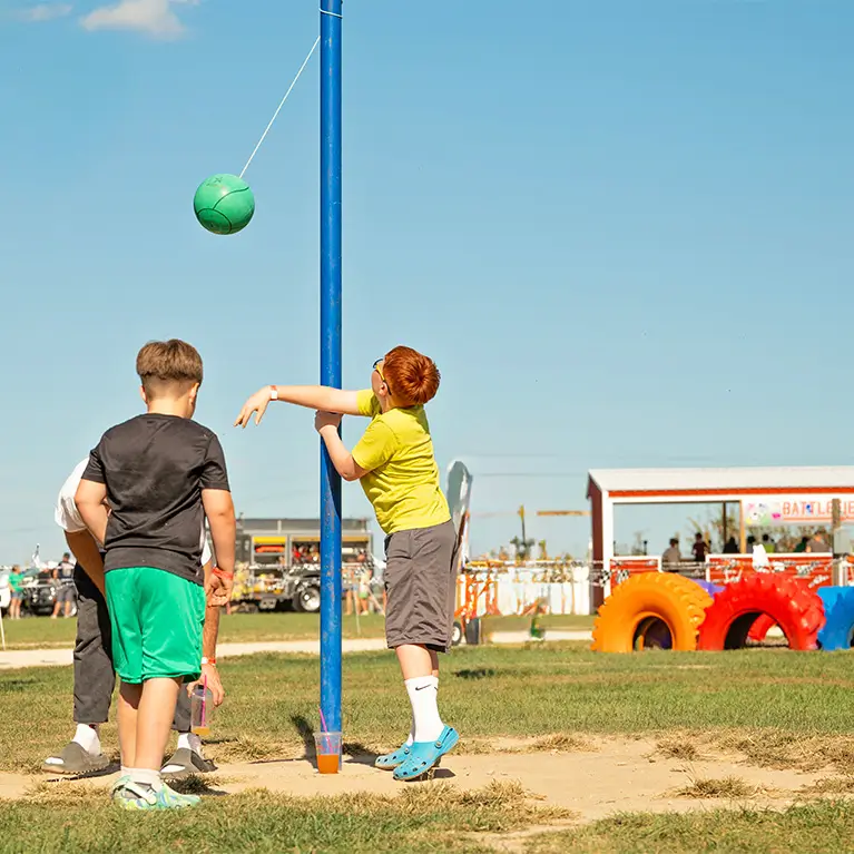 A group of boys playing tetherball.
